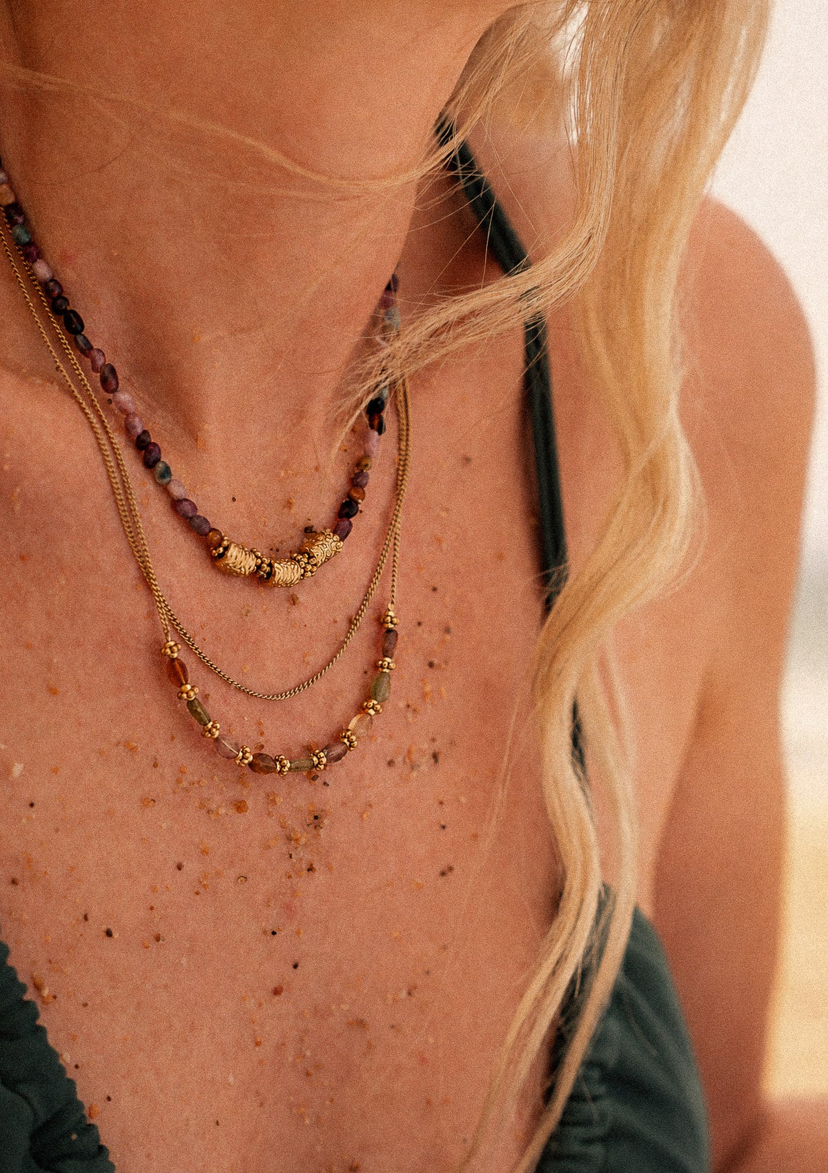 Collier ras-de-cou Harmonie Vivante en Tourmaline multicolore d'Inde porté au cou en accumulation sur plage, bijou assemblé en France par Namaka