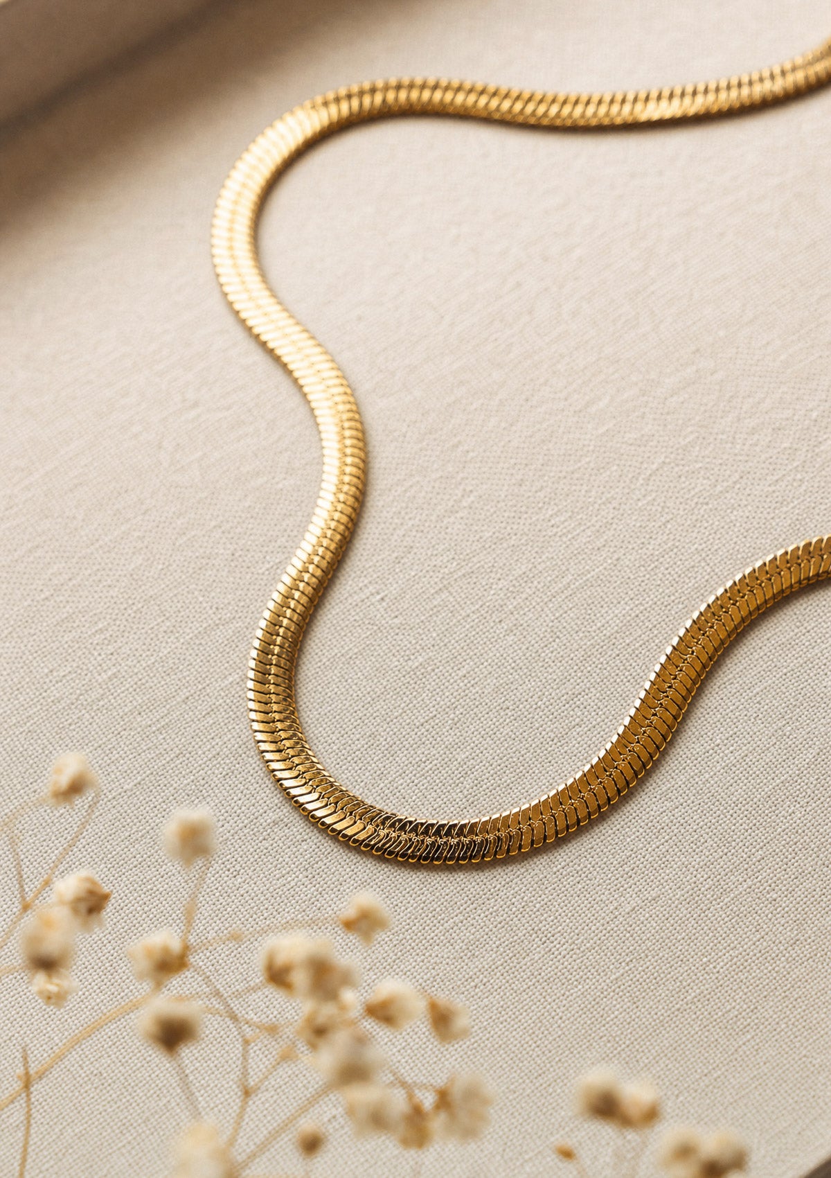 Collier chaîne serpent plate en acier inoxydable doré, maille fluide effet seconde peau au tombé lumineux signé Namaka