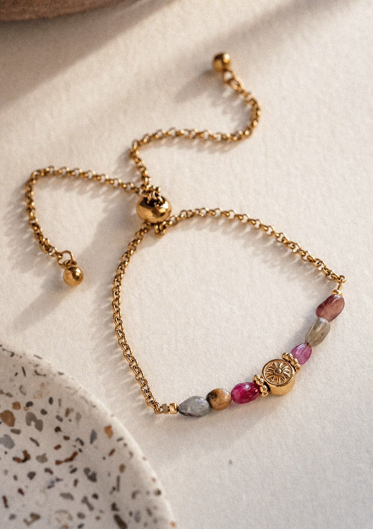 Bracelet Garde Dorée packshot ajustable coulissant, pierres de Tourmaline multicolore ovales et médaille soleil doré au centre – Namaka collection Solaire, assemblé en France