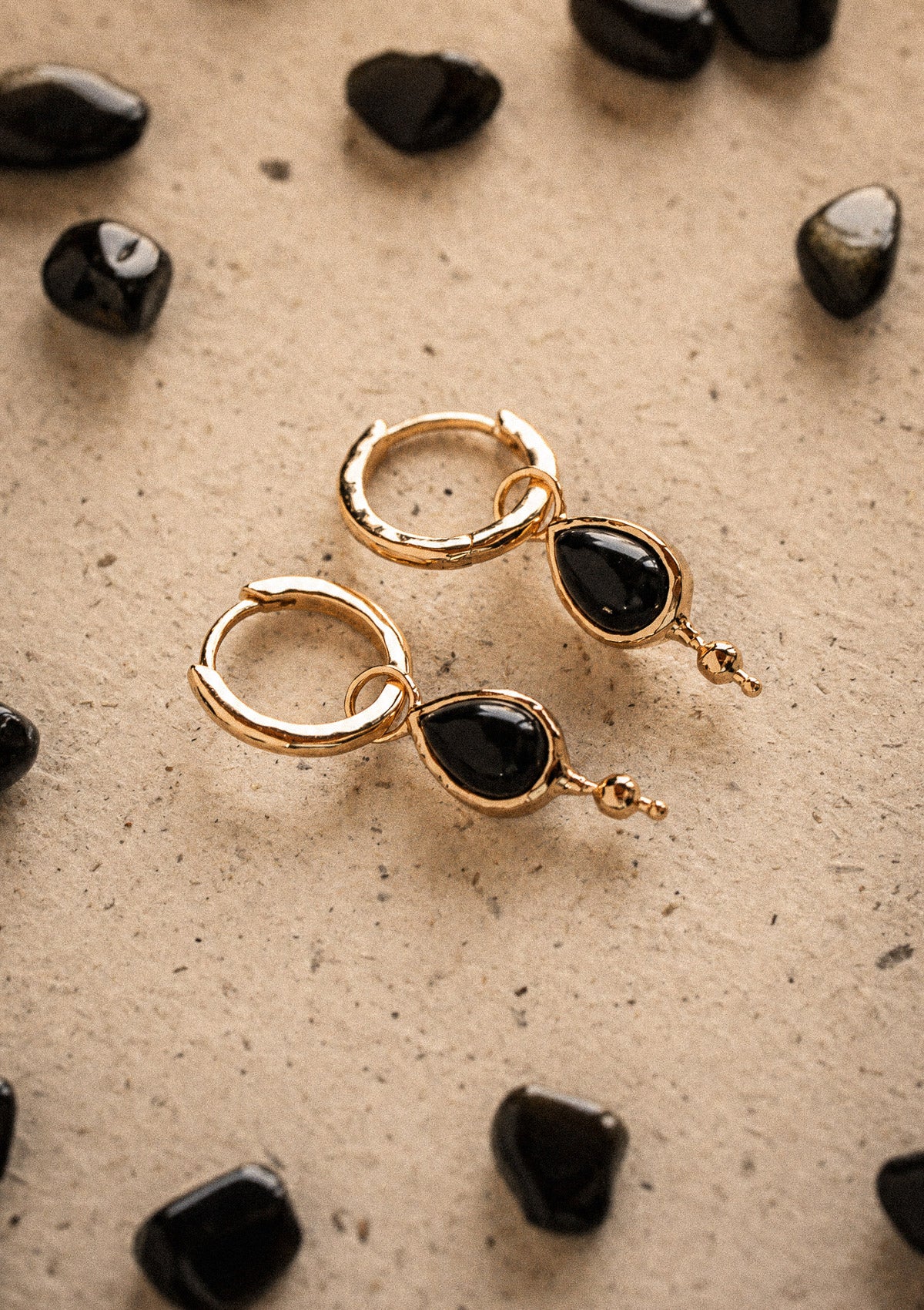 Packshot deux créoles or recyclé 18 carats à pampilles amovibles goutte Onyx Noir cabochon, entourées de galets d'Onyx polis