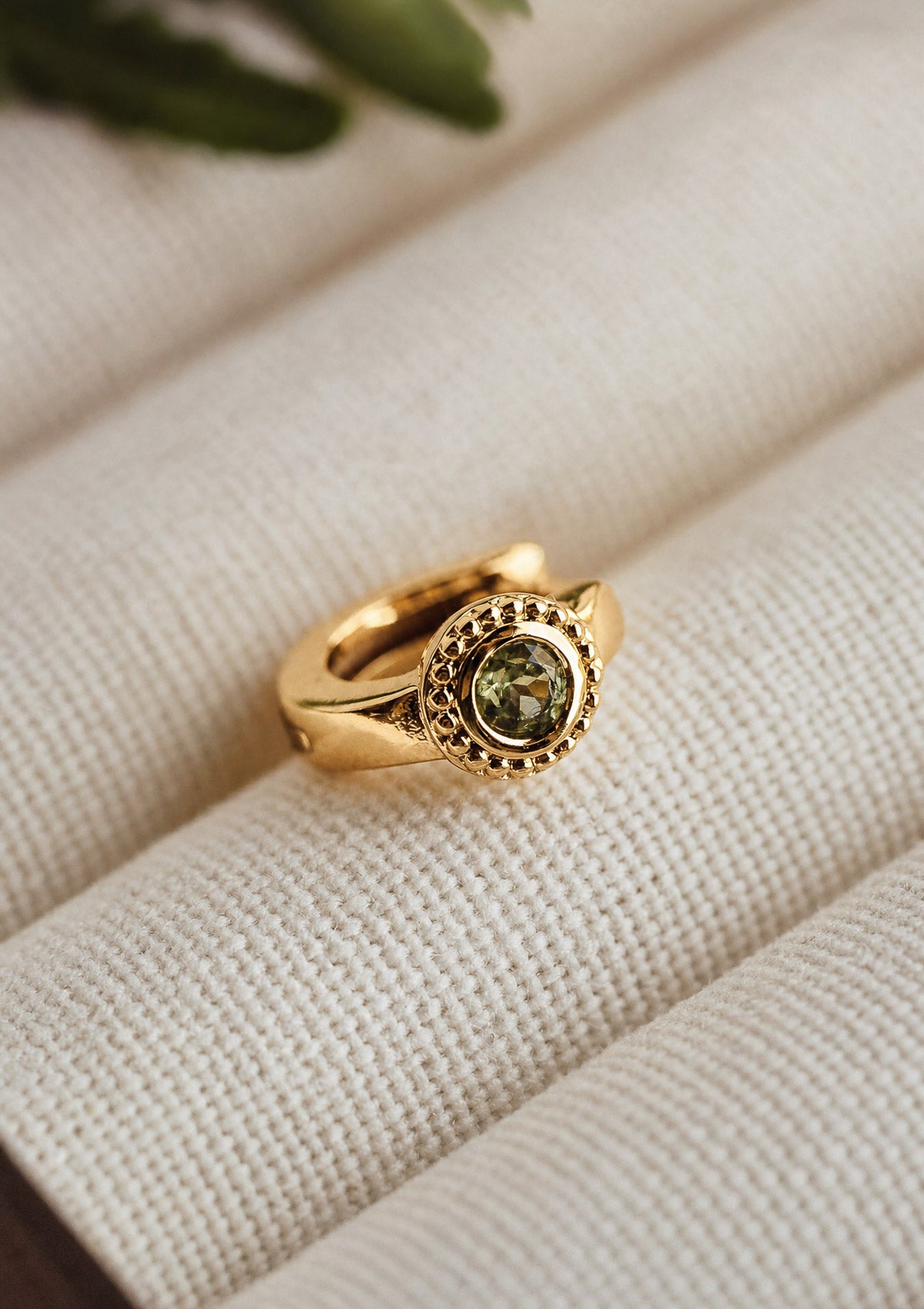 Mini créole en or recyclé 18 carats sertie d'un Péridot naturel rond, boucle d'oreille au format huggie signée Namaka