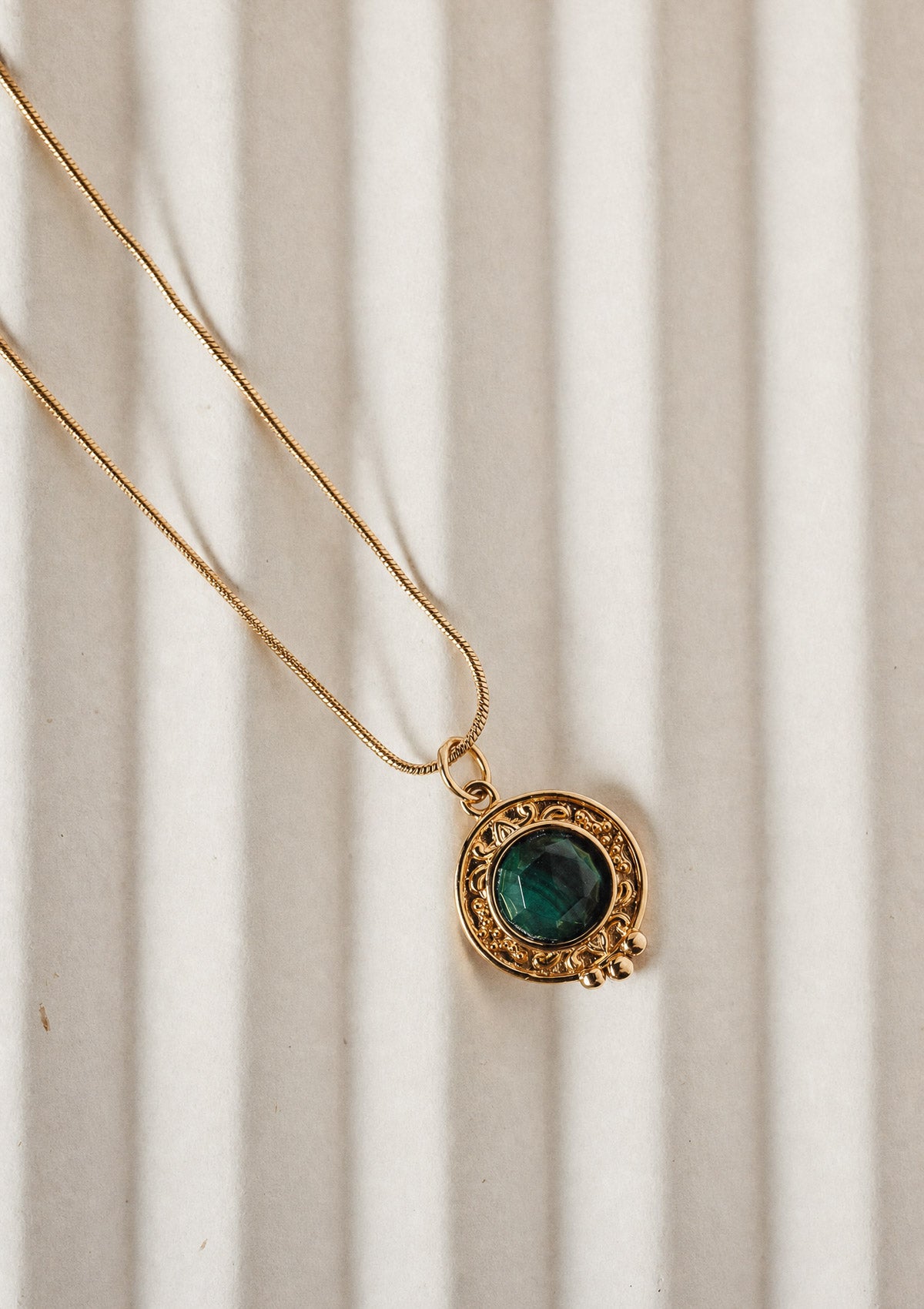 Pendentif rond en or recyclé 18 carats serti d'une Malachite naturelle au vert profond et bordure perlée, chaîne serpent dorée signé Namaka