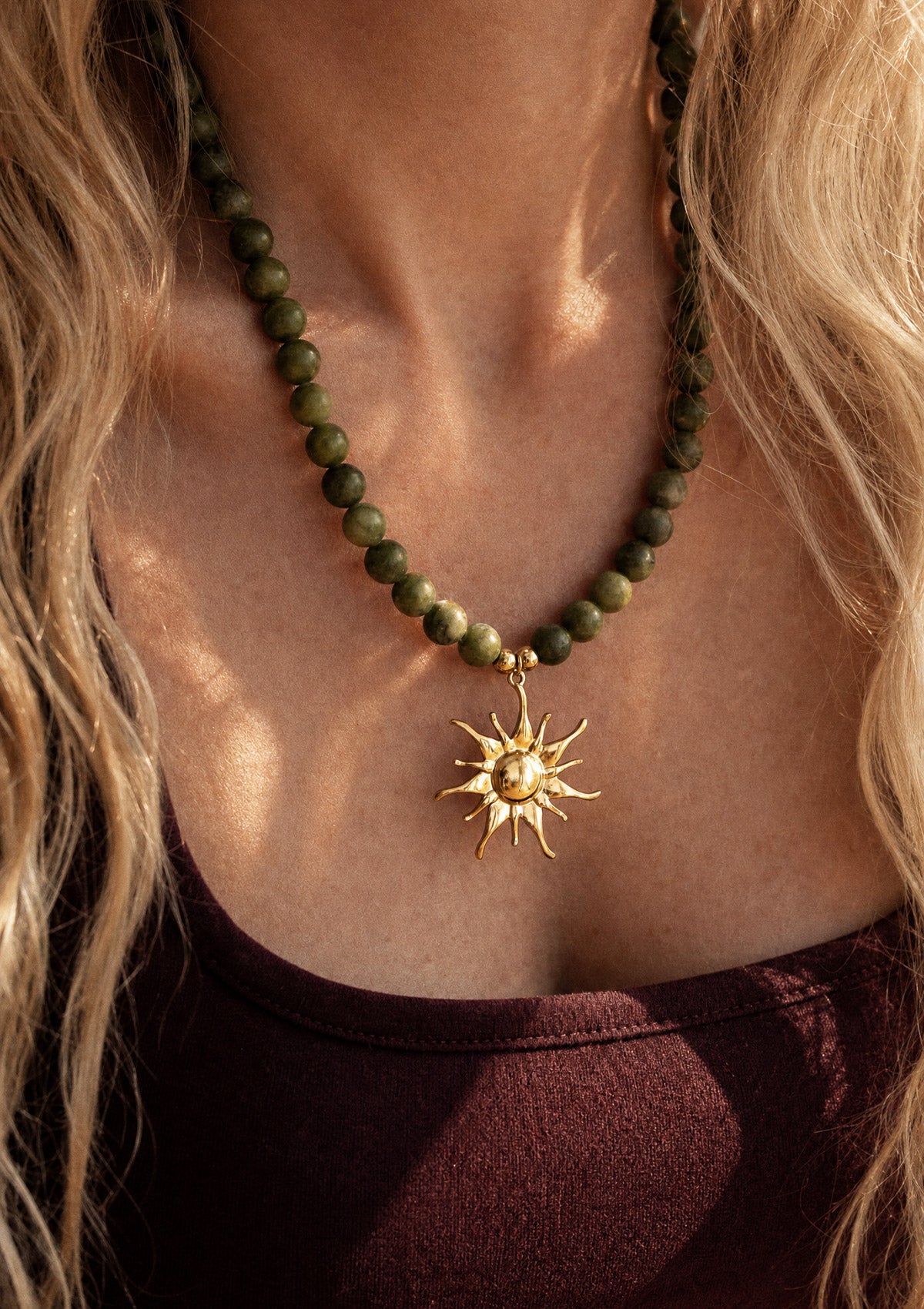 Gros collier Jade Soleil Vivant porté au cou avec tenue bohème, pendentif solaire doré et perles vertes naturelles, bijou assemblé en France par Namaka