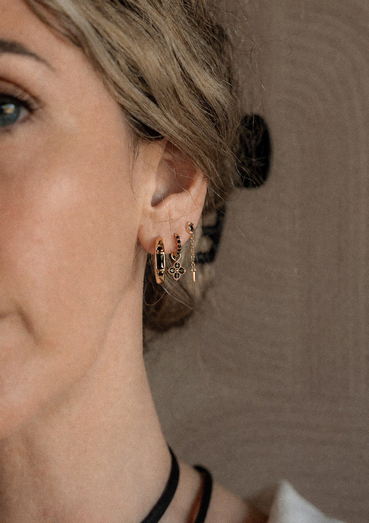 Trois boucles d'oreille or recyclé 18 carats Onyx Noir portées en accumulation : créole barrette, mini créole trèfle, puce fleur chaîne pique