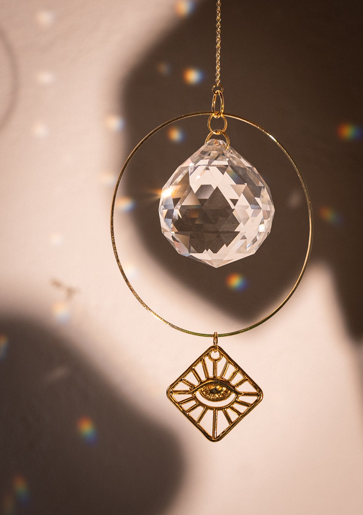 Petit Sun catcher avec cristal arc-en-ciel et oeil en métal doré.