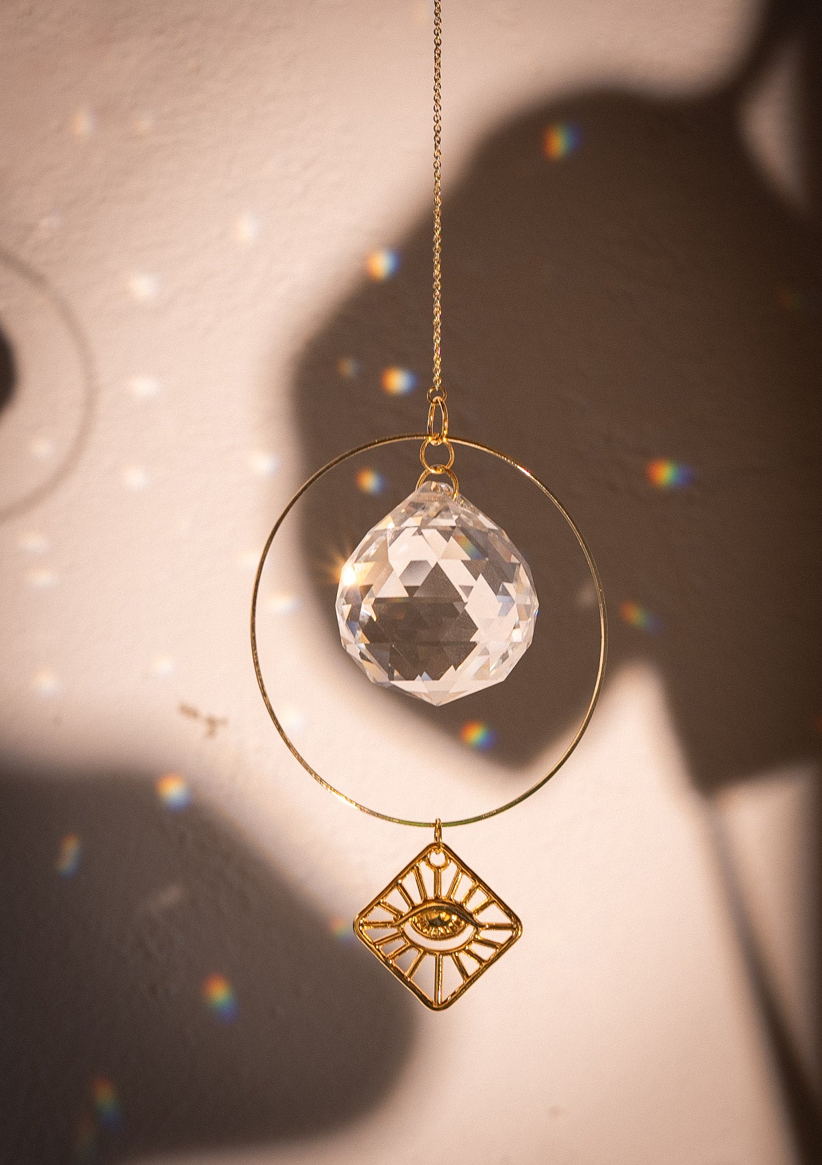 Petit Sun catcher avec cristal arc-en-ciel et oeil en métal doré.