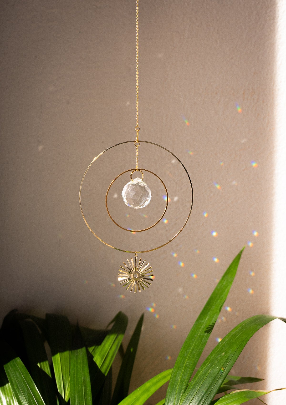 Petit Sun catcher avec cristal arc-en-ciel et soleil en métal doré.