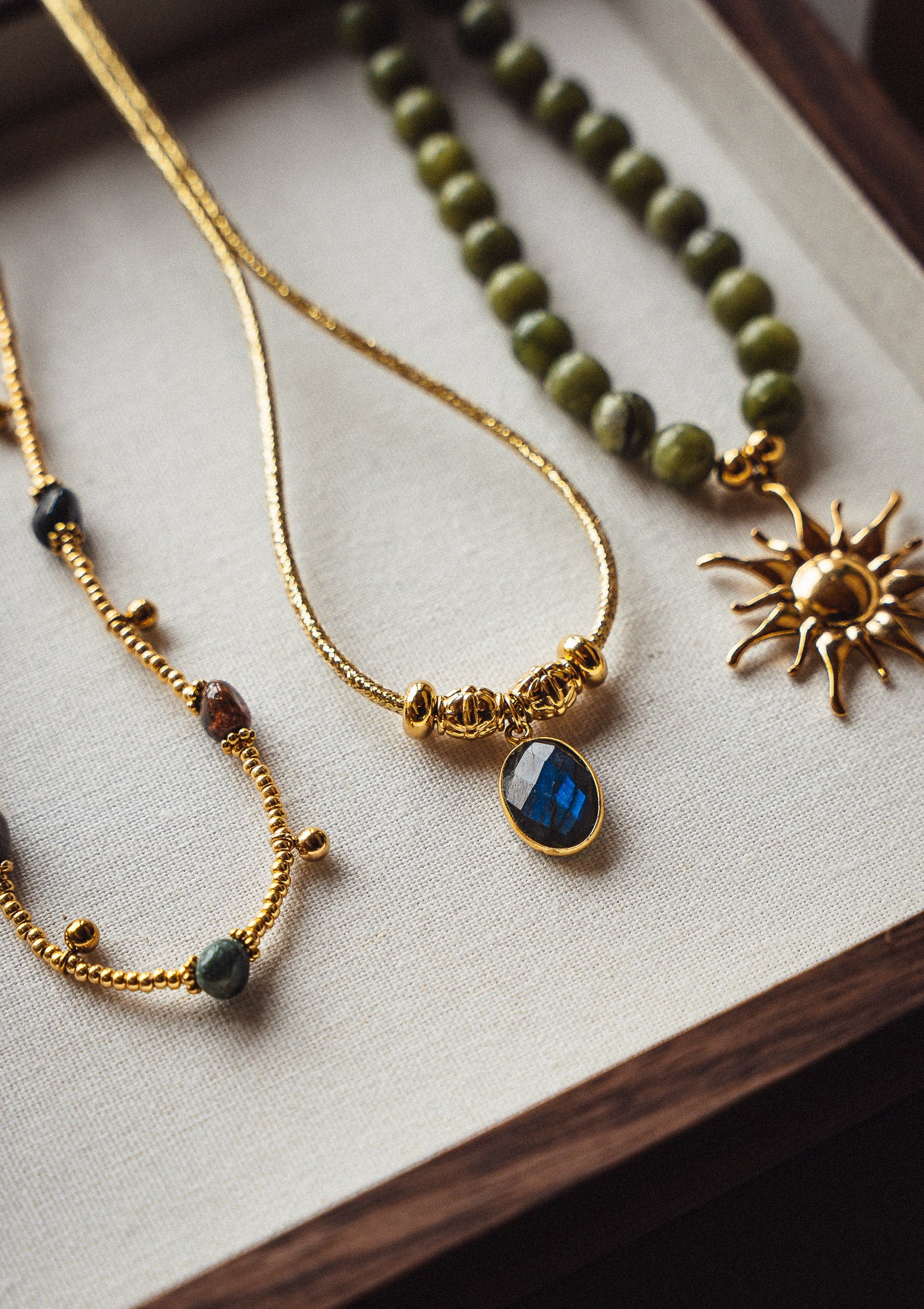 Gros plan sur collier rigide en acier inoxydable doré avec pierre de Labradorite ovale, bijou tendance femme style torque