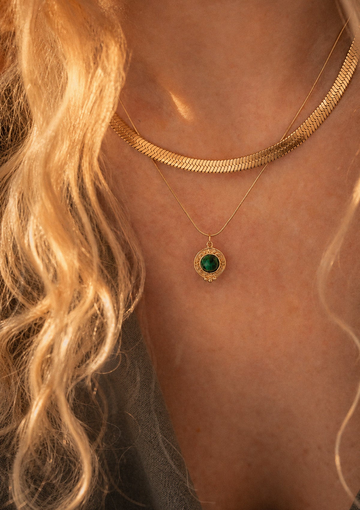 Collier Malachite Cœur Indomptable au pendentif vert porté en accumulation avec une chaîne serpent plate dorée Namaka