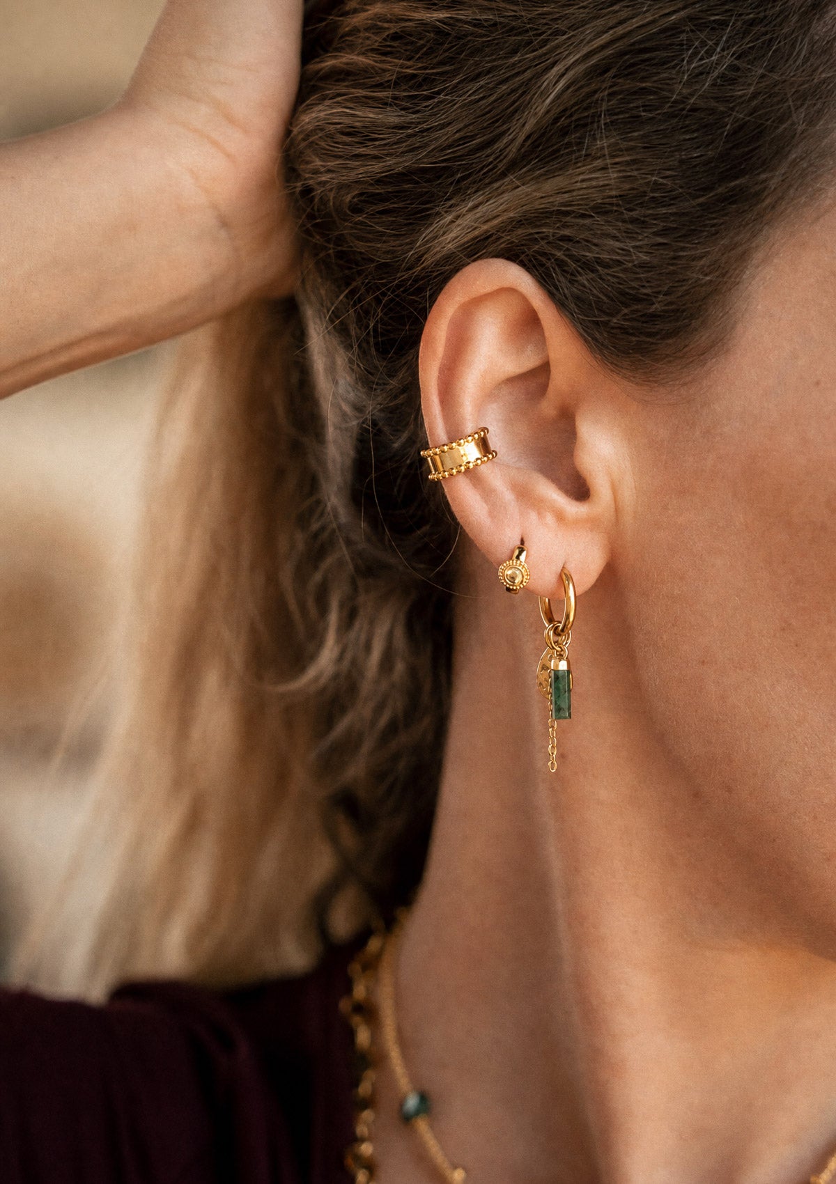 Créole Émeraude portée à l'oreille avec ear cuff doré perlé et mini créole Péridot, accumulation chakra du cœur assemblée en France par Namaka