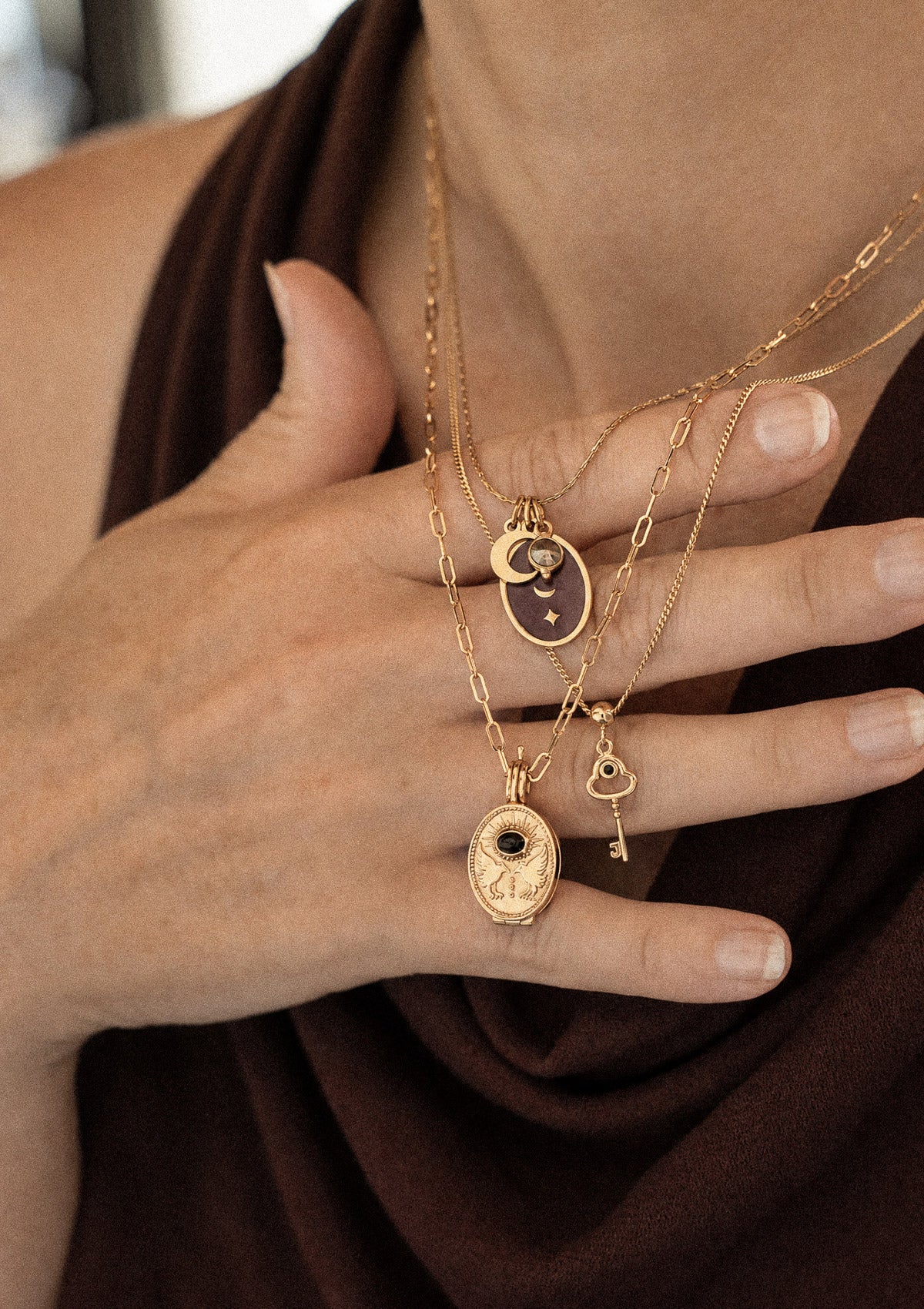 Collier médaillon Oracle Lunaire émail bordeaux Pyrite porté sur drapé velours marron avec Chemin se Révèle Onyx et mini clé Onyx