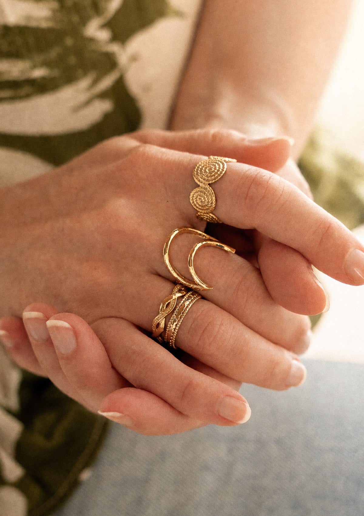 Bague croissant de lune en or recyclé portée en accumulation avec la bague torsadée et la bague spirale Namaka