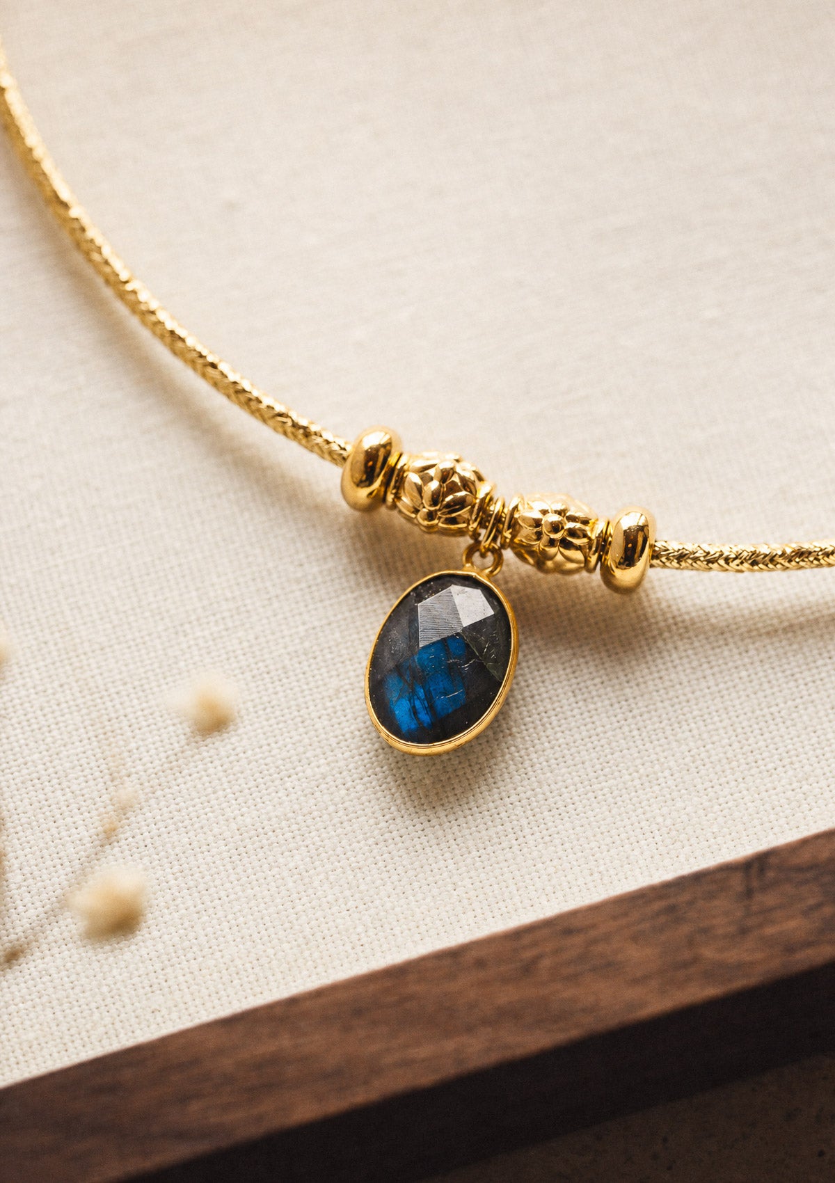 Détail du pendentif Labradorite naturelle aux reflets bleus, serti d'or sur collier rigide assemblé en France par Namaka