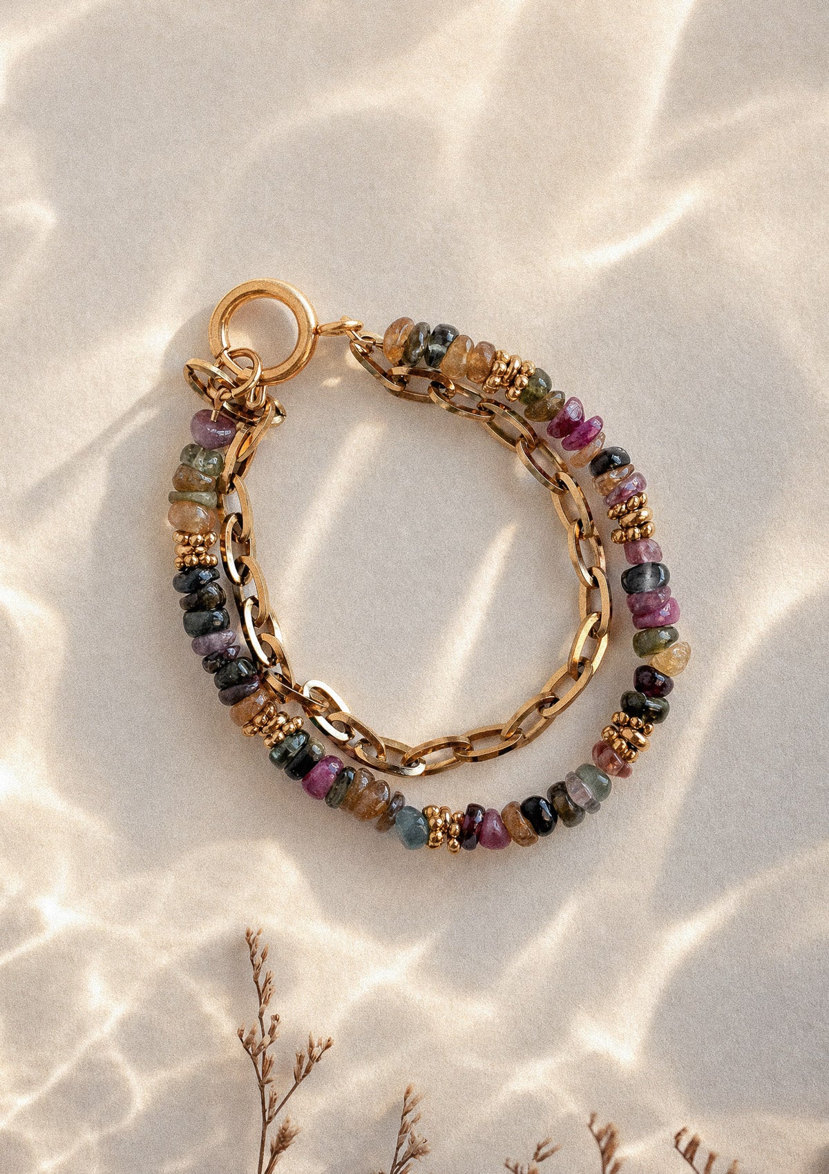 Bracelet Alliance Protectrice packshot double rang, chaîne dorée grosse maille et perles roulées de Tourmaline multicolore du Brésil sur sable – Namaka collection Solaire, assemblé en France