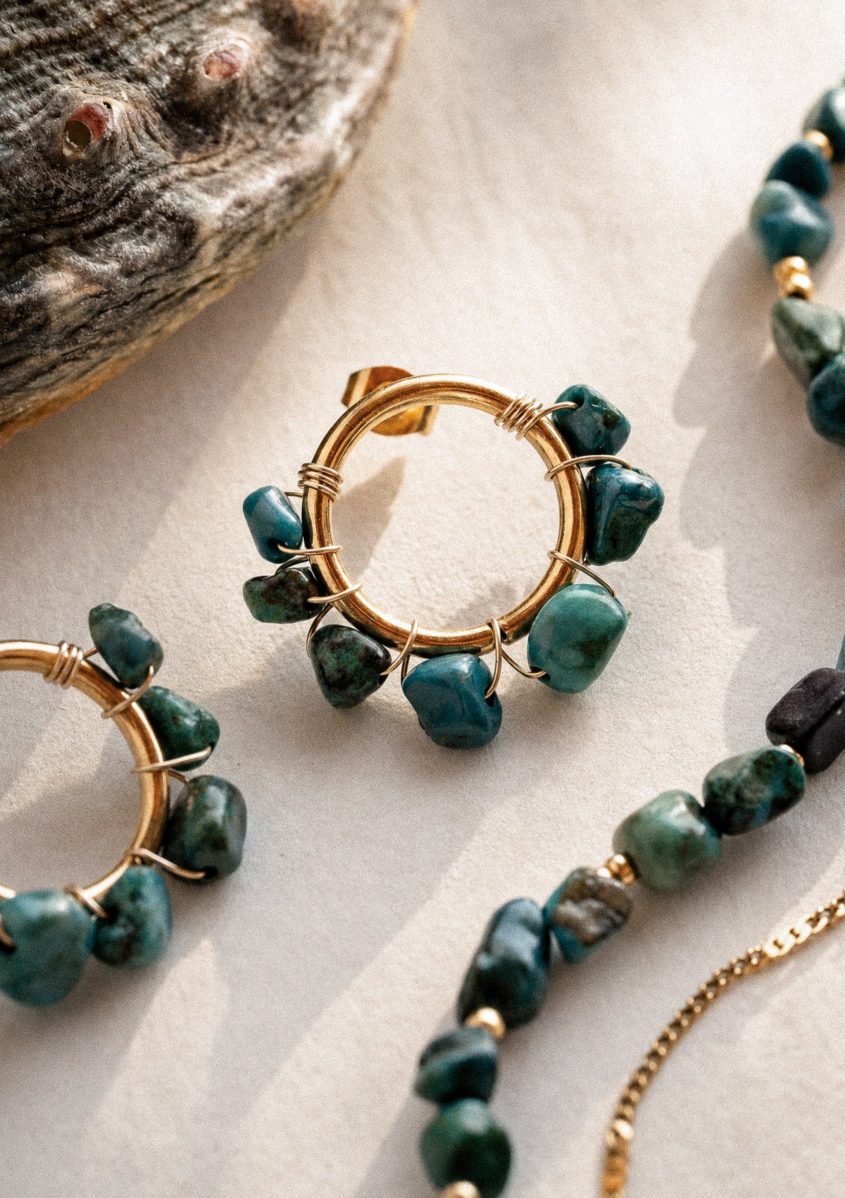 Gros plan Boucles Cercles Azurite Peau salée en scène avec coquillage nacré et cheville double Azurite en accumulation – Namaka collection Solaire, assemblé en France
