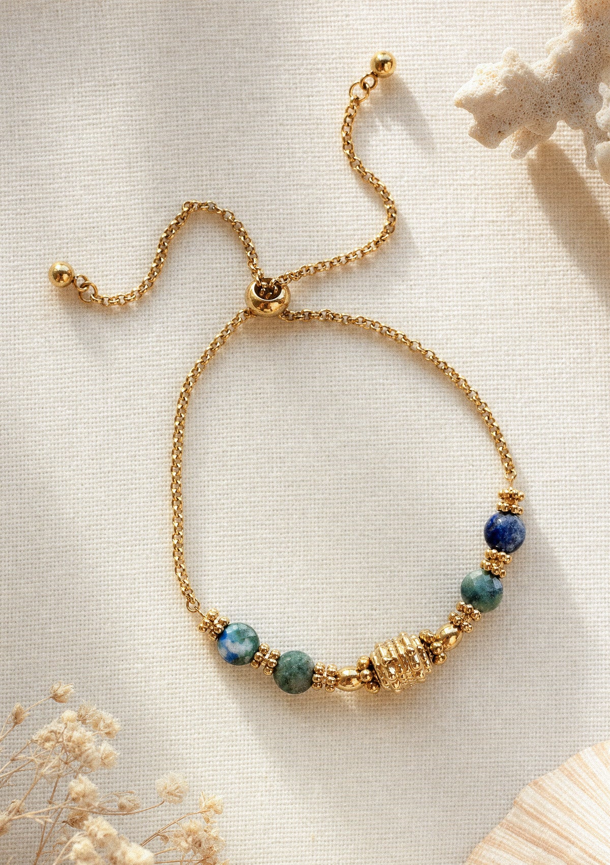 Bracelet Ligne d'horizon posé sur toile crème avec corail blanc, chaîne fine ajustable et perles Azurite Lapis – Namaka collection Solaire, assemblé en France
