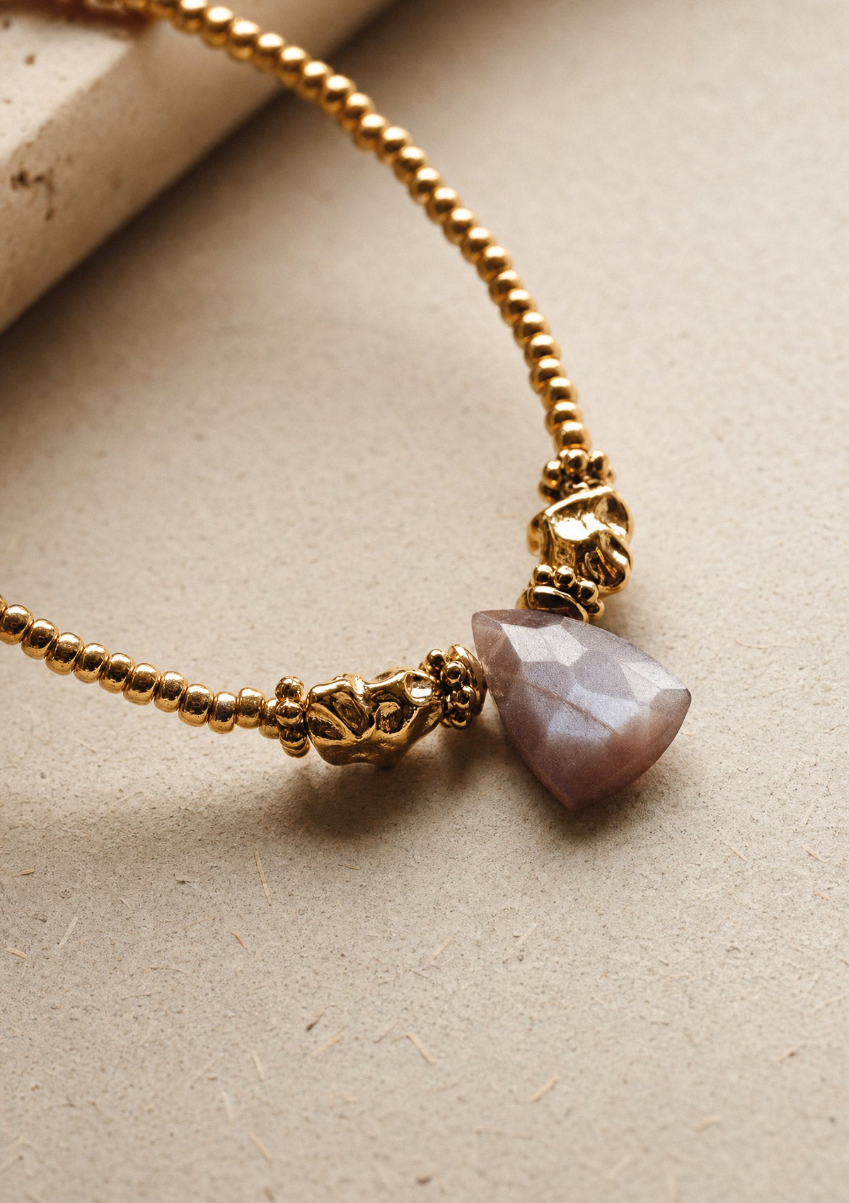 Détail du pendentif triangle en Pierre de Lune brune naturelle facettée sur collier perles Miyuki assemblé en France par Namaka