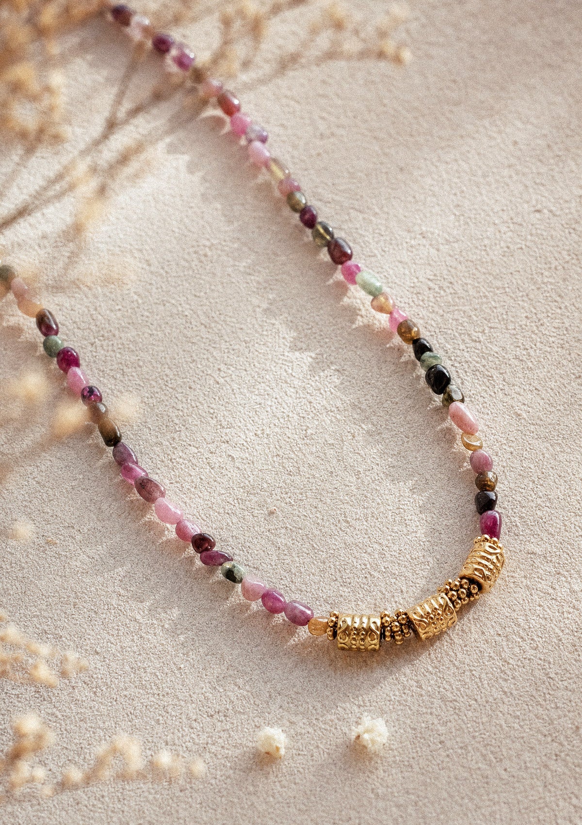 Collier Harmonie Vivante packshot sur sable, ras-de-cou en perles roulées de Tourmaline multicolore d'Inde et trois barrettes dorées ethniques – Namaka collection Solaire, assemblé en France