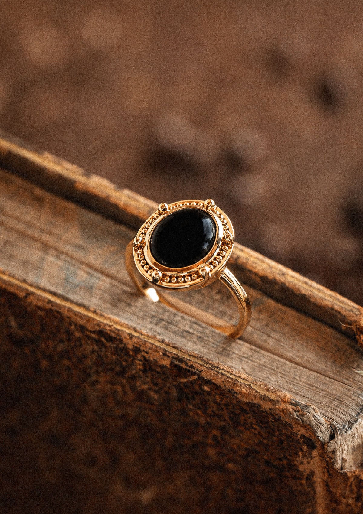 Packshot bague or recyclé 18 carats sertie cabochon ovale Onyx Noir contour perlé double, pierre de protection et d'ancrage