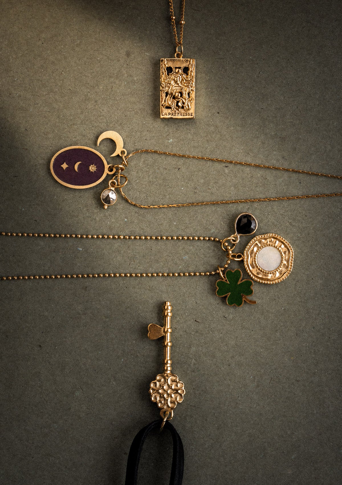 Bijoux Dark Academia sur papier kraft : collier tarot La Prêtresse, médaillon Oracle Lunaire émail bordeaux, gri-gri Onyx et clé satin