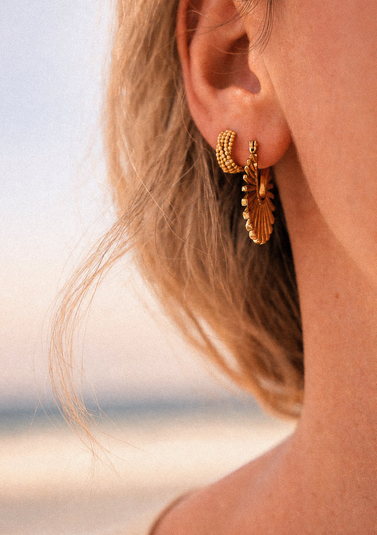 Boucles Soleil Rayonnant portées en accumulation solaire avec créole perlée dorée, pendant en éventail doré rayonnant à l'oreille en bord de mer – Namaka collection Solaire