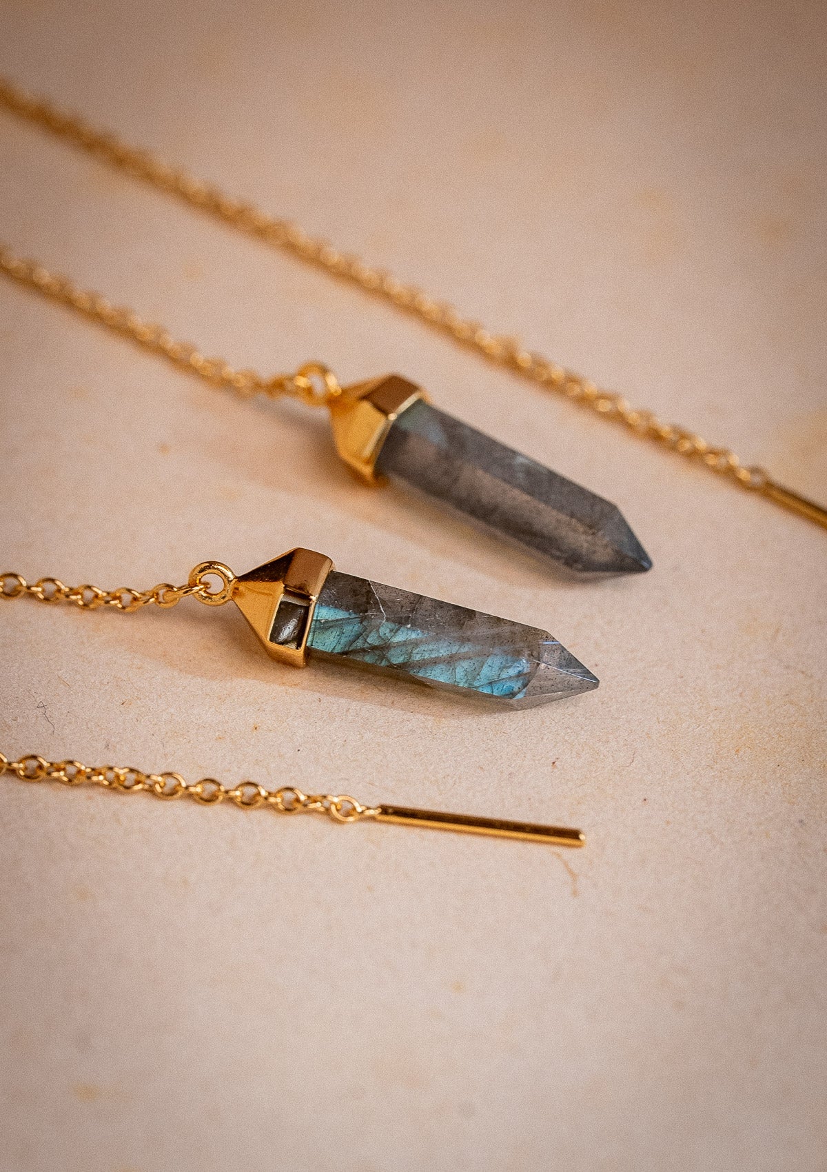 Clous d’oreilles pendants avec cristal hexagonal et chaine à travers l'oreille