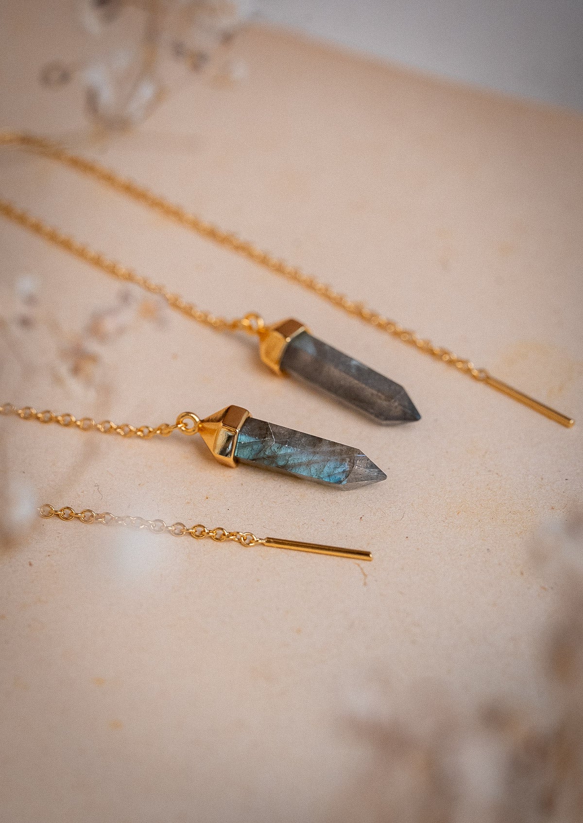 Clous d’oreilles pendants avec cristal hexagonal et chaine à travers l'oreille