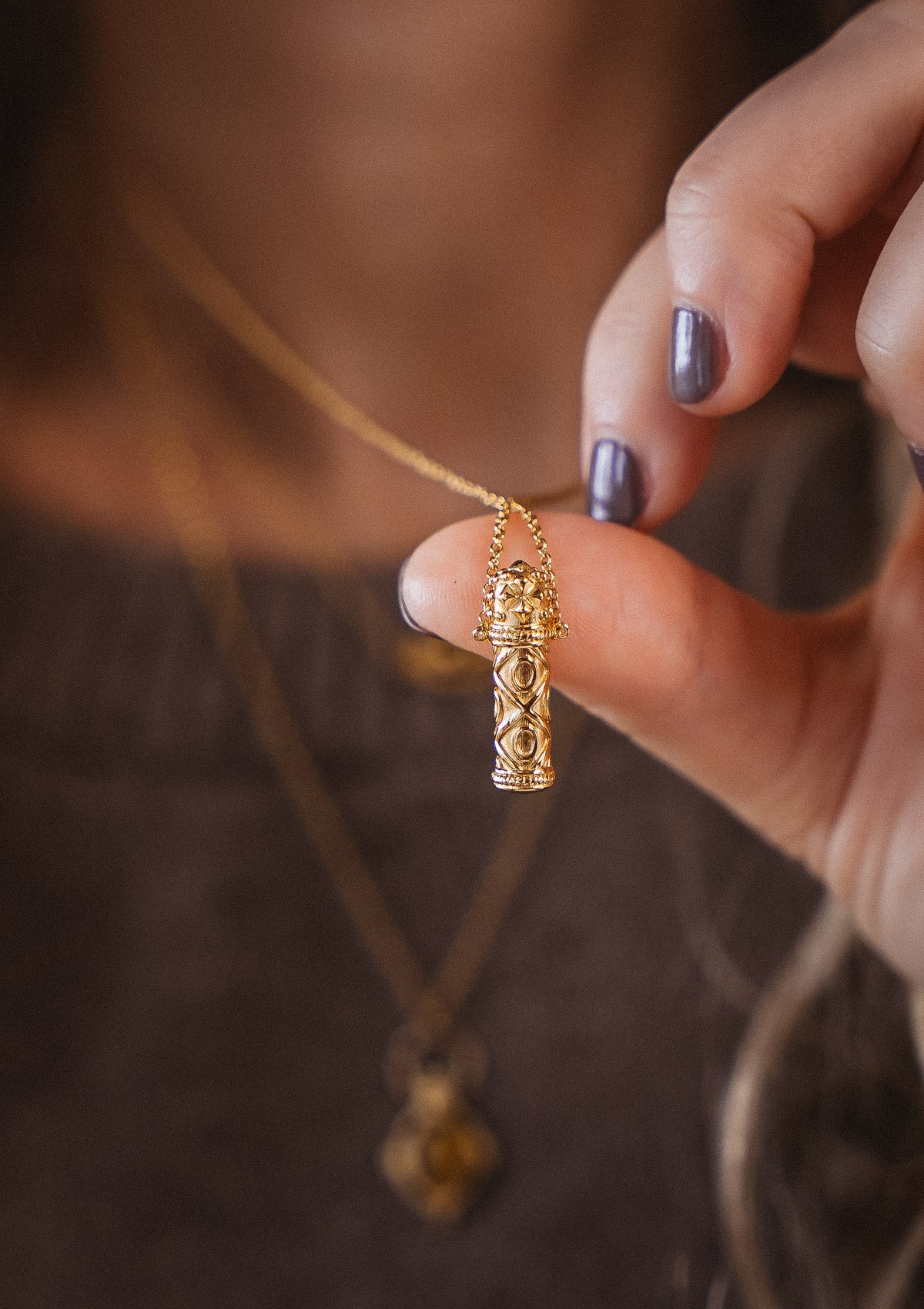 Collier talisman en forme de cylindre sculpté, à l'allure antique