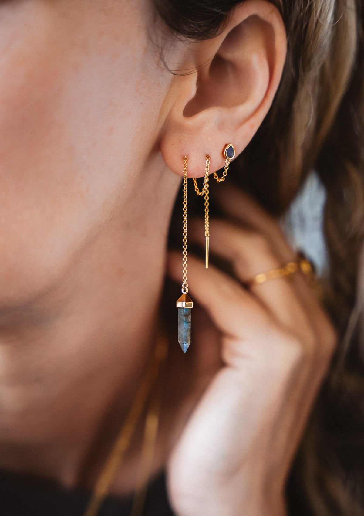 Clous d’oreilles pendants avec cristal hexagonal et chaine à travers l'oreille