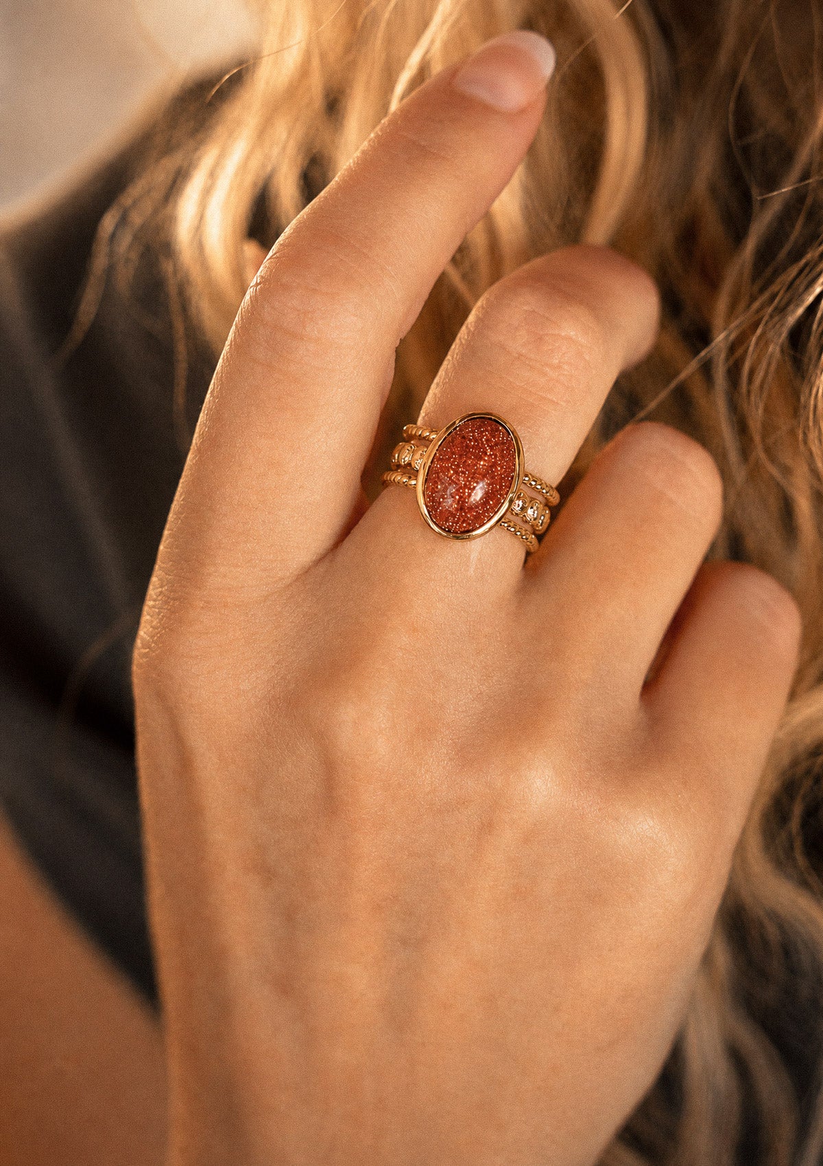 Bague Pierre de Sable portée à la main, anneau double torsadé en or recyclé 18 carats au cabochon ovale brillant signé Namaka