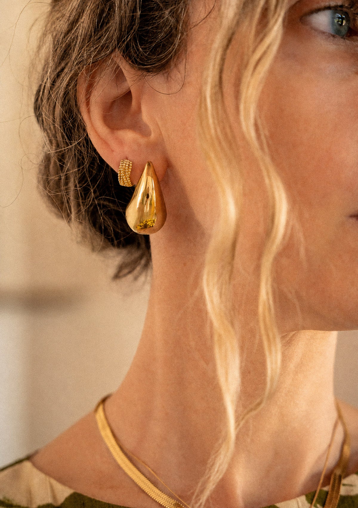 Détail des boucles d'oreilles gouttes Vague Organique portées de profil avec mini créole perlée et collier chaîne serpent Namaka