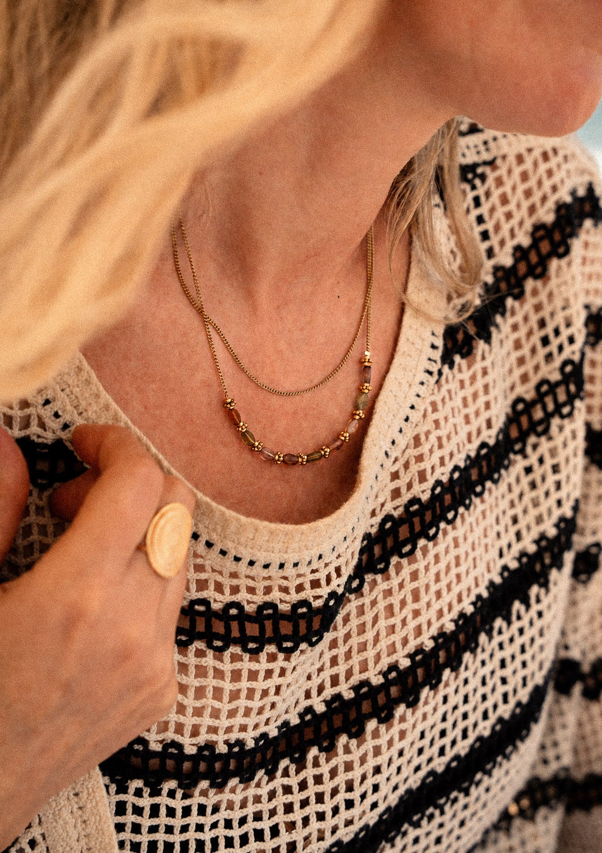 Partir léger — chaînes fines superposées, pierres de couleur et bague dorée